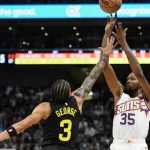 Suns vs Jazz players battling for possession during an intense NBA game, showcasing the rivalry's competitiveness.